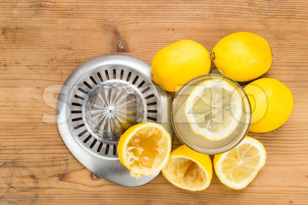 Freshly squeezed organic lemon juice with glass and squeezer. Stock Photo