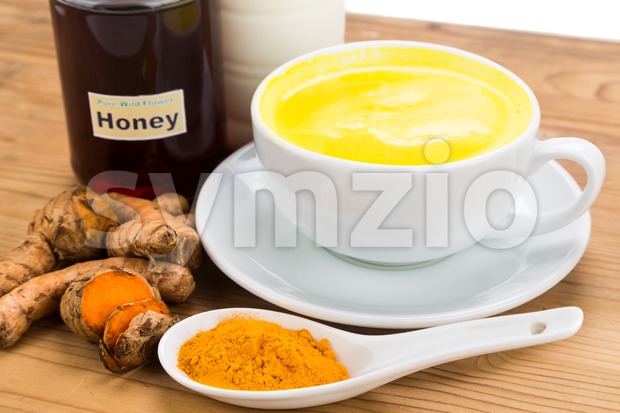 Turmeric roots with milk and honey drinks for beauty and health. Stock Photo