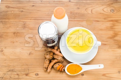 Turmeric roots with milk and honey drinks for beauty and health. Stock Photo