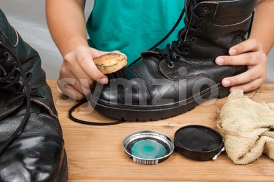 Person polishing a worn out men boots shoe Stock Photo