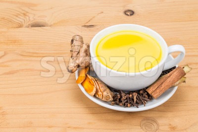 Healthy turmeric milk tea with ginger, cinnamon, cloves, black pepper Stock Photo