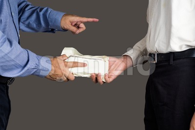 Man handling an envelope full of money to another person while pointing his finger Stock Photo
