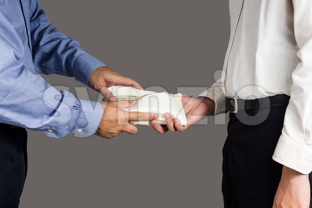 Man handling an envelope full of money to another person Stock Photo