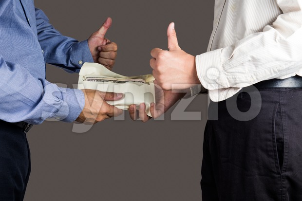 Man handling an envelope full of money to another person while making thumb up sign Stock Photo