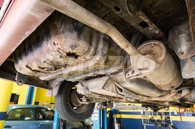 Focus on rusty, damaged, corroded undercarriage of car at workshop Stock Photo