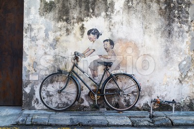 PENANG, DECEMBER 16, 2015:  Mural artwork by artist Ernest Zacharevic entitled Kids On Bicycle. The mural is located at Leboh Armenian. Stock Photo