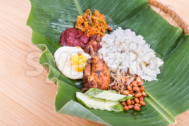Traditional nasi lemak cuisine on banana leaf with fried chicken Stock Photo