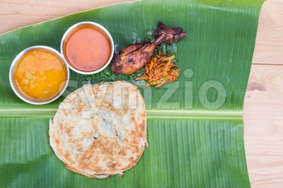 Traditional roti prata served on banana leaf with curry dhal. Stock Photo