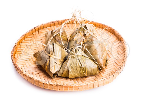 Bunch of Chinese rice dumpling placed on traditional rattan tray Stock Photo