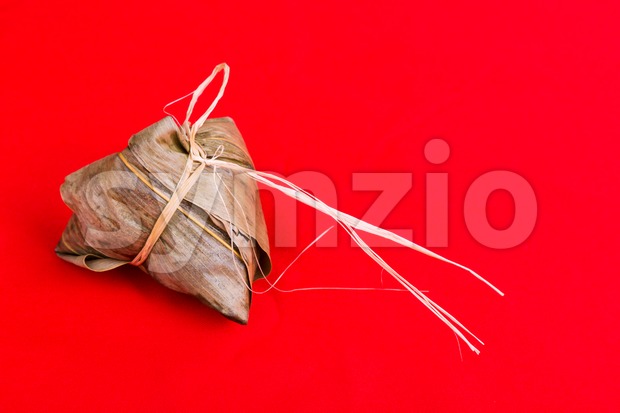 Fresh Chinese rice dumpling or zongzi against red background Stock Photo