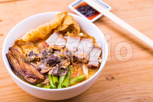 Delicious spicy curry noodle with roast pork and cockles Stock Photo