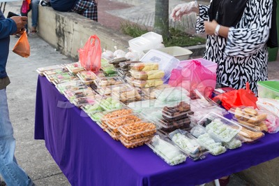 Vendor selling assorted Malay sweet cakes food at street stall Stock Photo