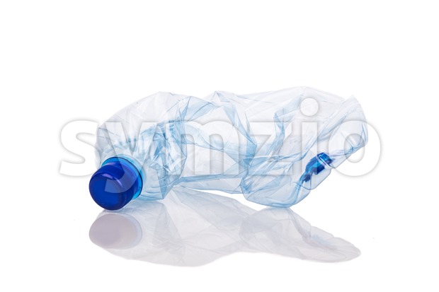Mineral water bottle crushed and crumpled against white background Stock Photo