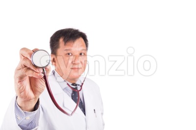 Selective focus on stethoscope held by Asian male medical doctor Stock Photo