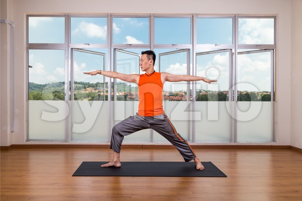 Yoga practitioner performing Warrior 2 or Virabhadrasana 2 pose Stock Photo