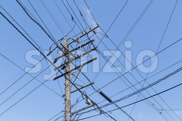 Electricity pole with wires grid with blue sky Stock Photo