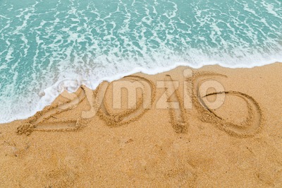 2016 inscription on sandy beach washed off with approaching wave Stock Photo
