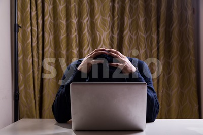 Hacker with both hands on head after failed attempt Stock Photo
