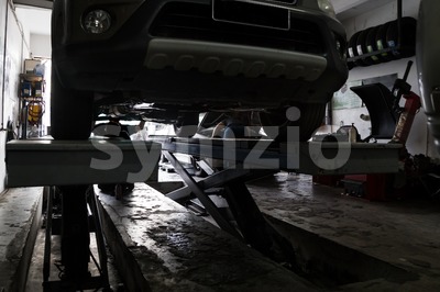 Silhouette of mechanics repairing car at small workshop garage Stock Photo