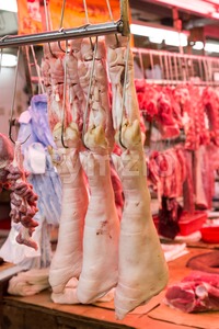 Fresh pork legs, intestine and meat at market stall Stock Photo