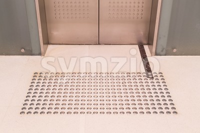 Tactile paving foot path for the blind entrance of elevator Stock Photo