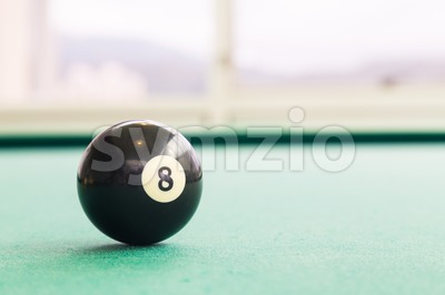 Closeup black snooker billards ball on table with green surface Stock Photo