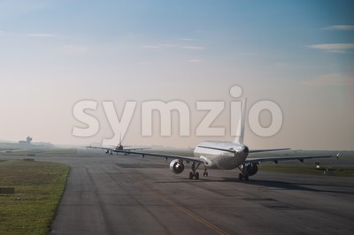 Commercial airplane queue taxiing to take off on runway Stock Photo