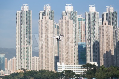 Drone doing surveillance take aerial photographs over cityscape Stock Photo