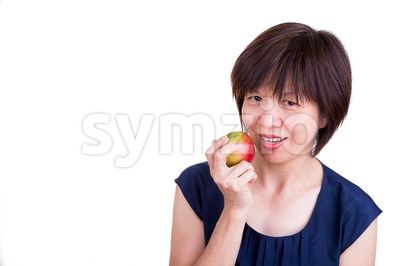 Pretty Asian women holding apple promotes healthy diet Stock Photo