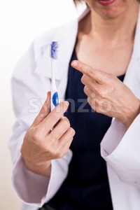 Dentist pointing at old worn out toothbrush bristle Stock Photo