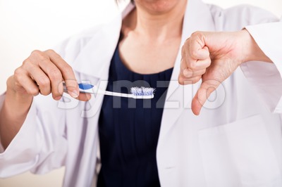 Dentist disapprove old worn out toothbrush bristle Stock Photo