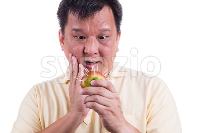 Conceptual of man holding apple with thorns fear suffer toothache Stock Photo