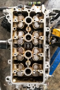 Worn uto car engine valves being serviced at garage Stock Photo