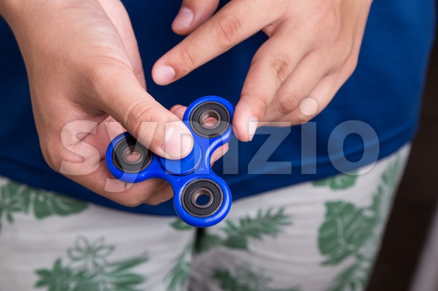 Teenager attempt to spin the fidget spinner Stock Photo