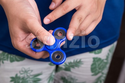 Teenager attempt to spin the fidget spinner Stock Photo