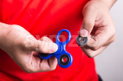 Person holding dislodged weight from fidget spinner, dangerous for kids Stock Photo