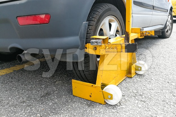 Car wheel clamp on street for illegal parking Stock Photo