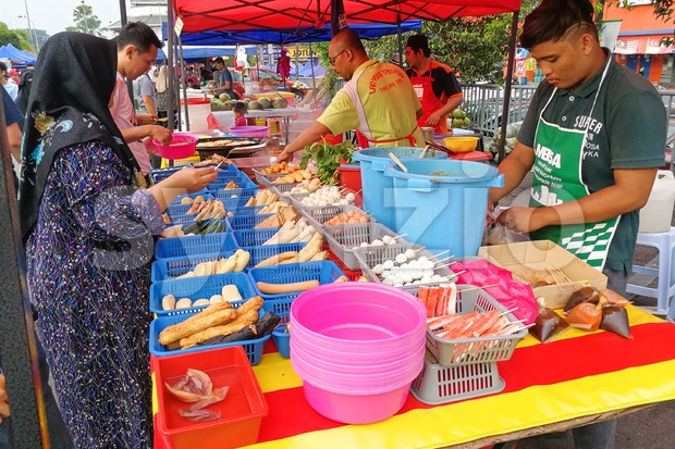 KUALA LUMPUR, MALAYSIA, May 29, 2016: Muslim shopper buying food from street vendor for breaking fast or iftar Stock Photo
