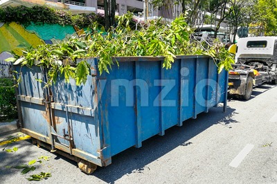 Garbage container latch with truck full of garden refuse woods Stock Photo