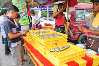 KUALA LUMPUR, MALAYSIA, June 2, 2017: Muslim shopper buying sweet desserts from street stall vendor for breaking fast or iftar Stock Photo