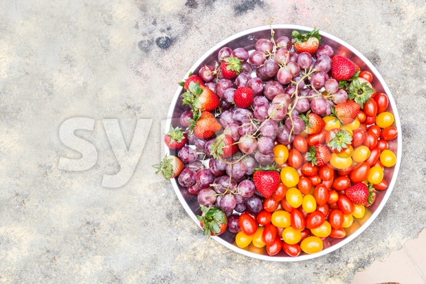 Tray of fresh and sweet organic grapes, strawberries, cherry tomatoes Stock Photo