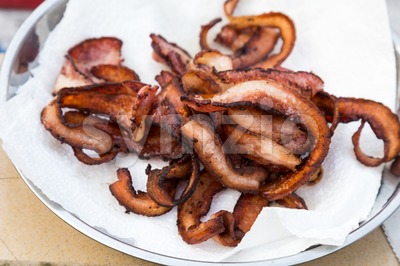 Crispy delicious fried bacon strips but unhealthy with burnt carbon Stock Photo