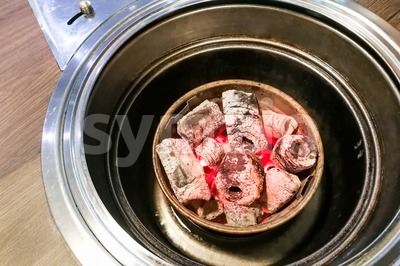 Korean restaurant barbecue pit with hot red charcoal Stock Photo