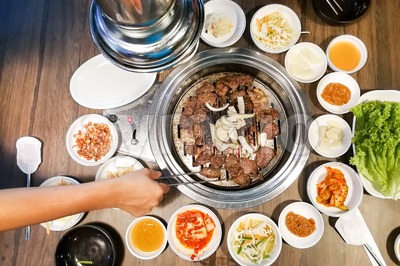 Person barbecue beef on bbq pit during korean meal set Stock Photo