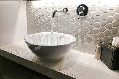 Modern wash basin with running water from tap faucet Stock Photo