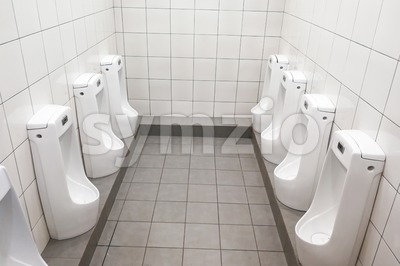 Modern clean hygienic men urinal ware in public washroom toilet Stock Photo