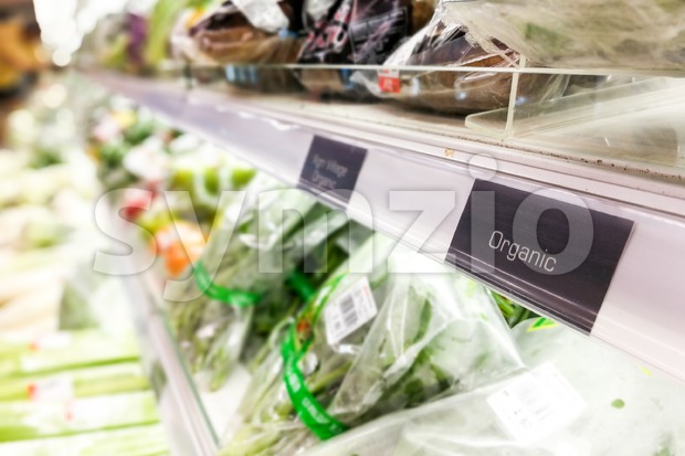 Organic food signage on modern supermarket vegetable aisle Stock Photo