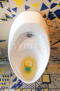 Clogged smelly men urinal sanitary ware in public restroom toilet Stock Photo