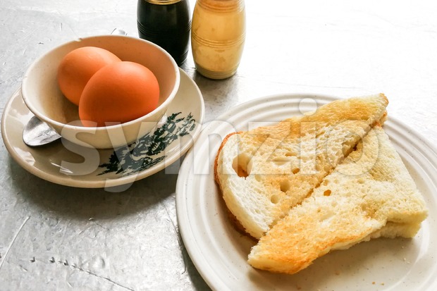 Asian traditional breakfast of half boiled eggs with toast bread Stock Photo