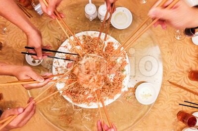 Motion hands with chopsticks tossing  Yee Sang meal in Malaysia Stock Photo
